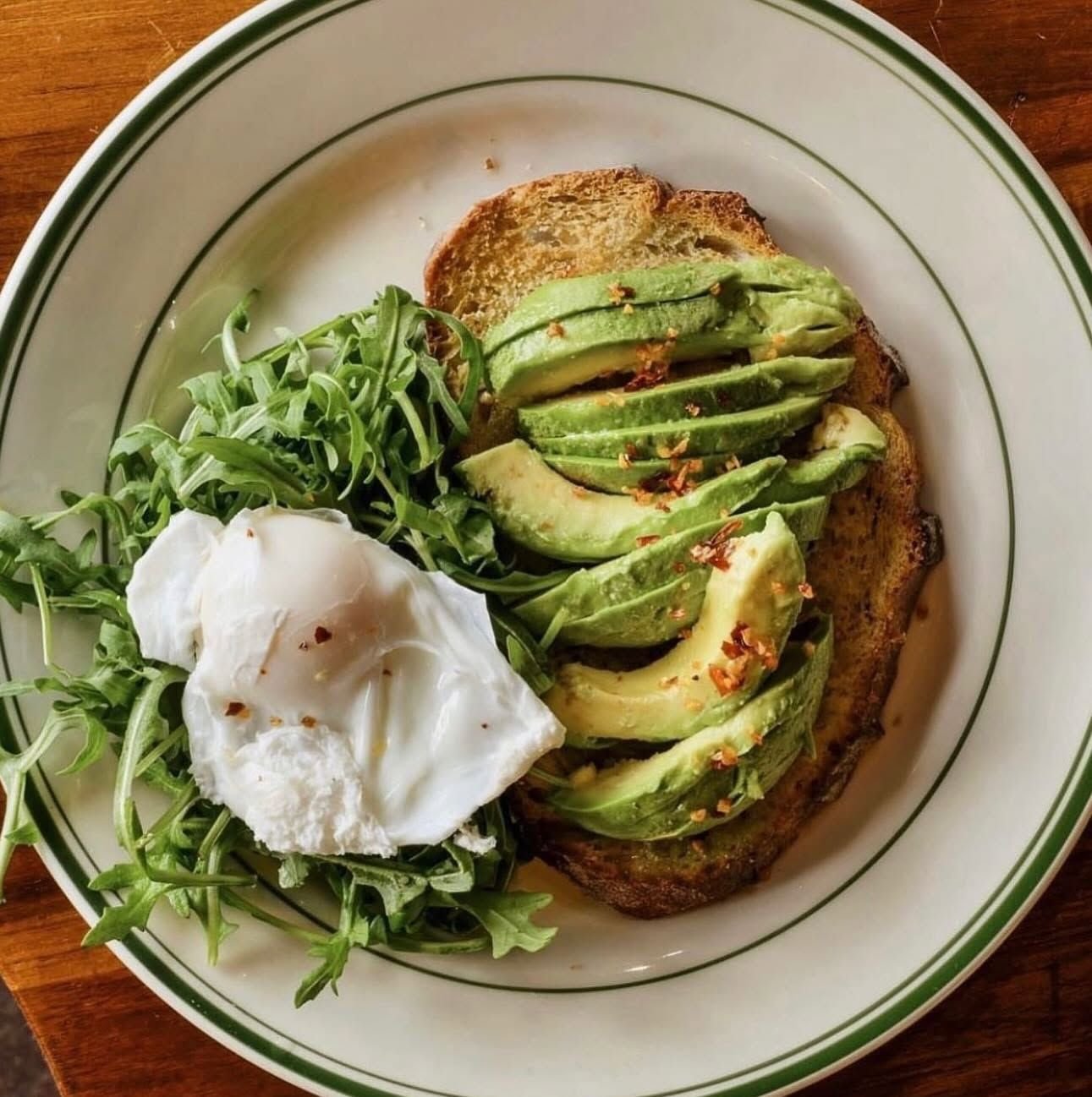 Avocado toast with poached egg and arugula