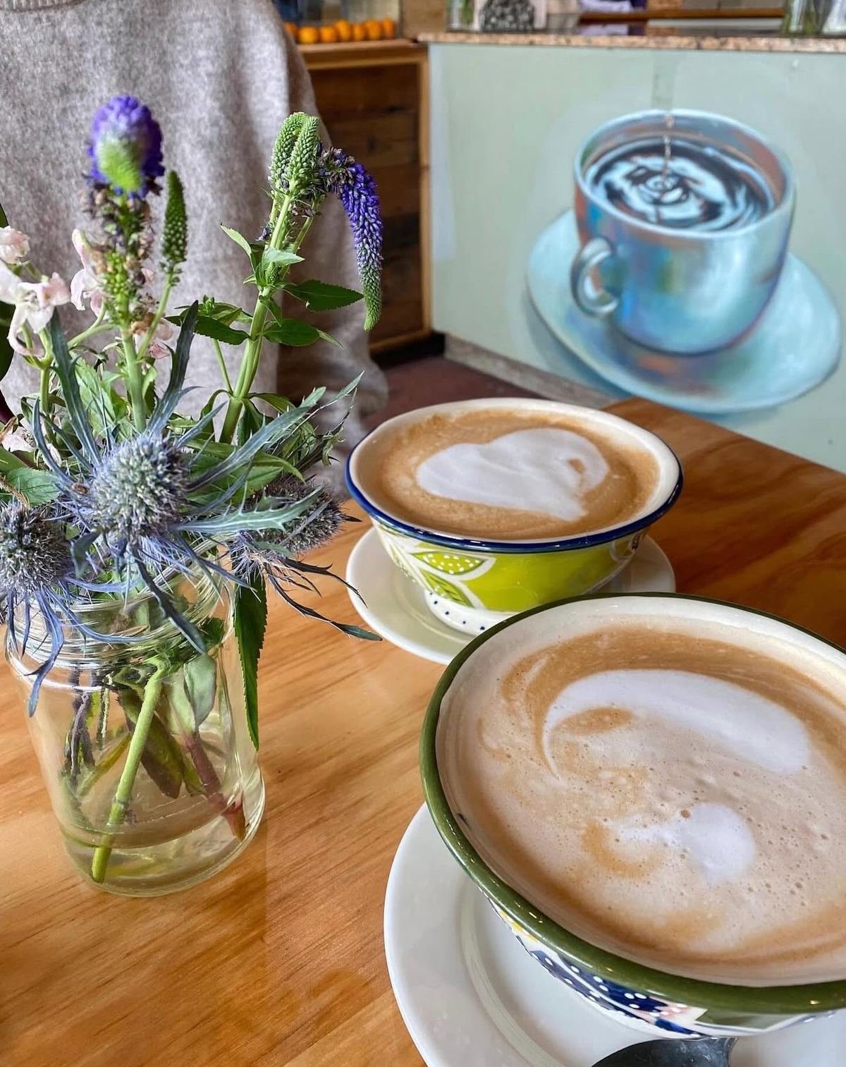 Lattes at the café, artwork on the wall behind